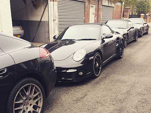 Row of black Porsches parked
